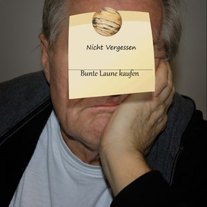 May include: A man with a yellow sticky note on his forehead. The note has a drawing of a wooden sphere and the text "Nicht Vergessen Bunte Laune kaufen".
