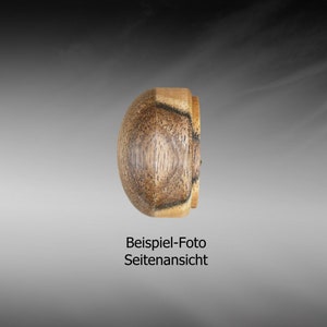 May include: Side view of a wooden knob with a dark brown and light brown wood grain pattern. The knob is round and has a smooth surface.