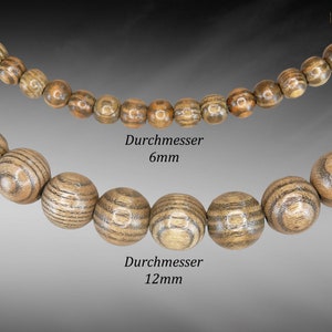 Può includere: Due fili di perline di legno, uno con perline da 6 mm e l'altro con perline da 12 mm. Le perline sono marroni con un motivo a venature del legno.