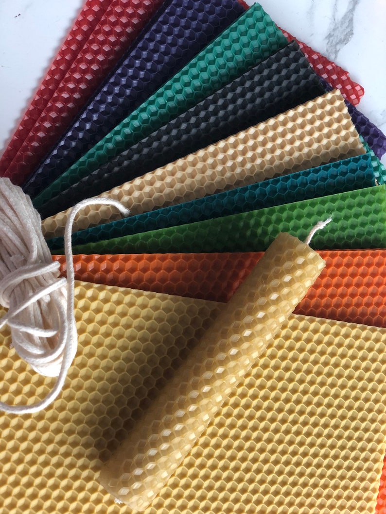 May include: Assortment of honeycomb wax sheets in various colours, including red, green, blue, and orange, with a single honeycomb wax candle and a spool of white twine.
