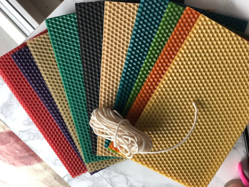 May include: A set of eight honeycomb wax sheets in various colours, including red, purple, green, black, and beige, with a ball of white twine.
