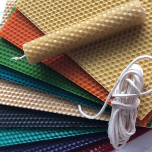 May include: A set of colourful honeycomb wax sheets with a natural beeswax candle and a spool of white cotton wick. The sheets are arranged in a fan shape, with the candle and wick in the centre.