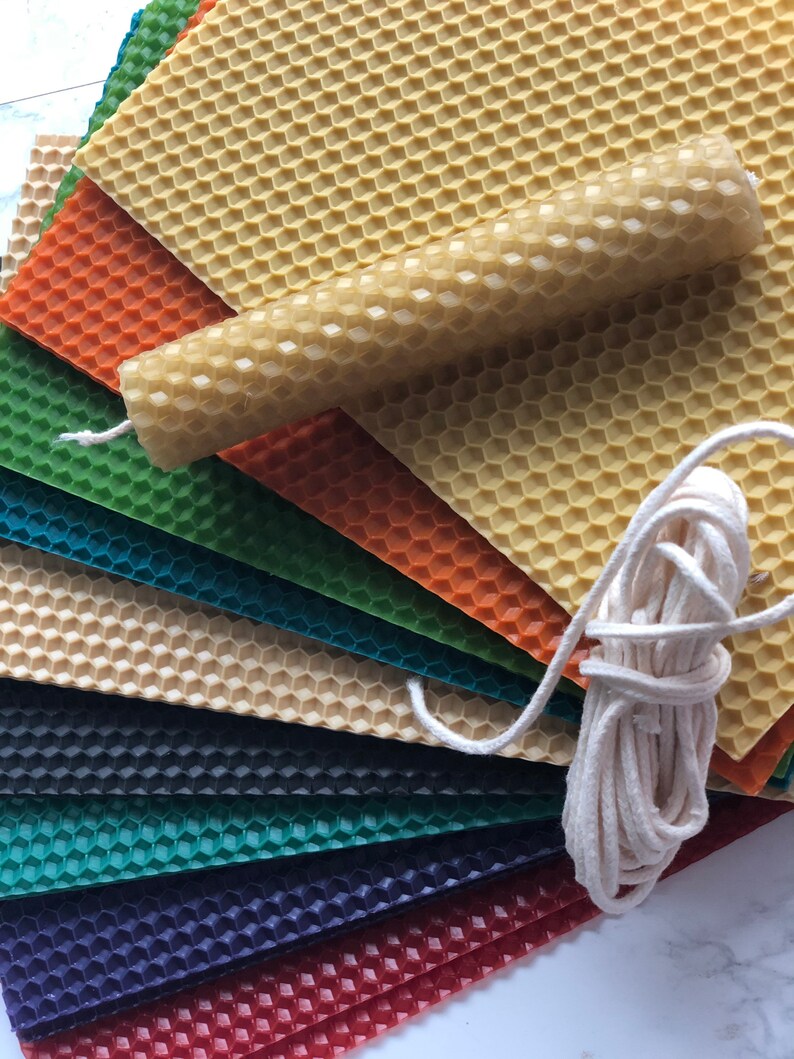 May include: A set of colourful honeycomb wax sheets with a natural beeswax candle and a spool of white cotton wick. The sheets are arranged in a fan shape, with the candle and wick in the centre.