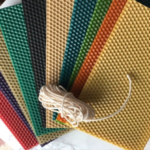May include: A set of eight honeycomb wax sheets in various colours, including red, purple, green, black, yellow, orange, and teal, with a roll of white twine.