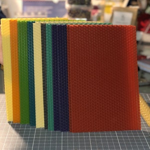 May include: A set of 10 sheets of honeycomb foundation for beekeeping. The sheets are in various colours, including orange, yellow, green, blue, and red.