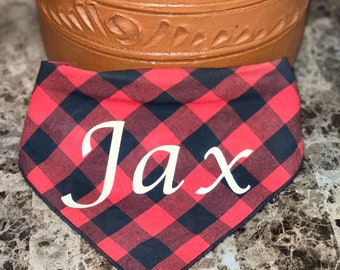 Könnte beinhalten: Rotes und schwarzes kariertes Halstuch mit dem Namen "Jax" in weiß.