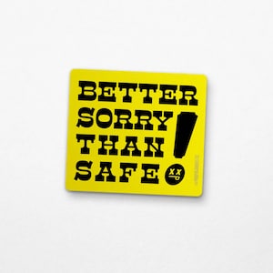 May include: A yellow square sticker with the phrase "BETTER SORRY THAN SAFE" in bold black letters. A black exclamation mark and a small smiley face are also on the sticker. The sticker has a white background.