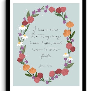 May include: A floral wreath with pink, orange, and purple flowers surrounds a quote from the Bible: "I have come that they may have life, and have it to the full." John 10:10.