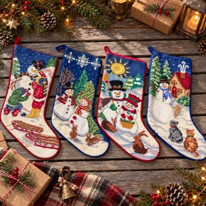 Può includere: Quattro calze natalizie ricamate a mezzo punto con scene invernali di pupazzi di neve, alberi di pino e animali. Ogni calza ha uno sfondo blu, un bordo rosso o blu e dettagliate immagini festive che includono slitte, conigli e una casa.