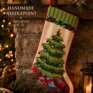 Puede incluir: Un calcetín navideño de punto de aguja hecho a mano con 100% lana. El calcetín presenta un árbol de Navidad verde decorado con adornos rojos y azules, con regalos envueltos en la base. Tiene un puño de rayas verdes y un borde rojo.