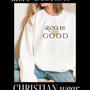 May include: White sweatshirt with the text "God is Still Good" in black and gold lettering. The sweatshirt is being worn by a person with long blonde hair and blue jeans. The text "CHRISTIAN wear" is at the bottom of the image.