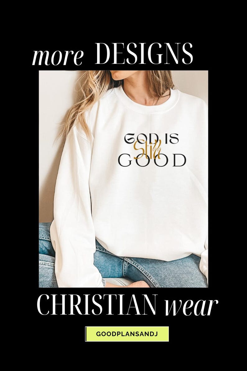 May include: White sweatshirt with the text "God is Still Good" in black and gold lettering. The sweatshirt is being worn by a person with long blonde hair and blue jeans. The text "CHRISTIAN wear" is at the bottom of the image.