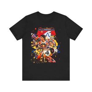 May include: Black t-shirt featuring a colorful graphic of a motocross racer on a KTM motorcycle. The design includes the number 4, the Red Bull logo, and the text "PRO MOTOCROSS". The image has a vibrant, action-packed aesthetic.