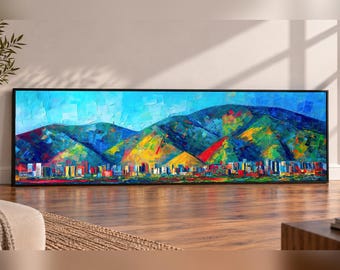 May include: A panoramic rectangular wall art piece featuring a vibrant, textured oil painting of a city skyline nestled beneath large, colorful mountains. The artwork uses bold strokes of blue, yellow, red, and green to depict the landscape.