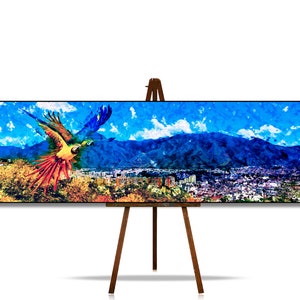 May include: A colorful painting of a parrot flying over a city with mountains in the background. The parrot is red, yellow, blue, and green. The city is brown and gray. The mountains are blue and purple. The sky is blue with white clouds.