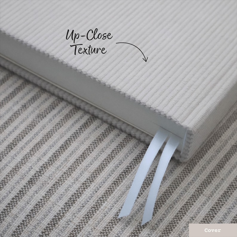 Puede incluir: Primer plano de una cubierta de cuaderno de terciopelo de pana blanca con un marcap&aacute;ginas de cinta blanca. El texto "Up-Close Texture" est&aacute; escrito en la cubierta.