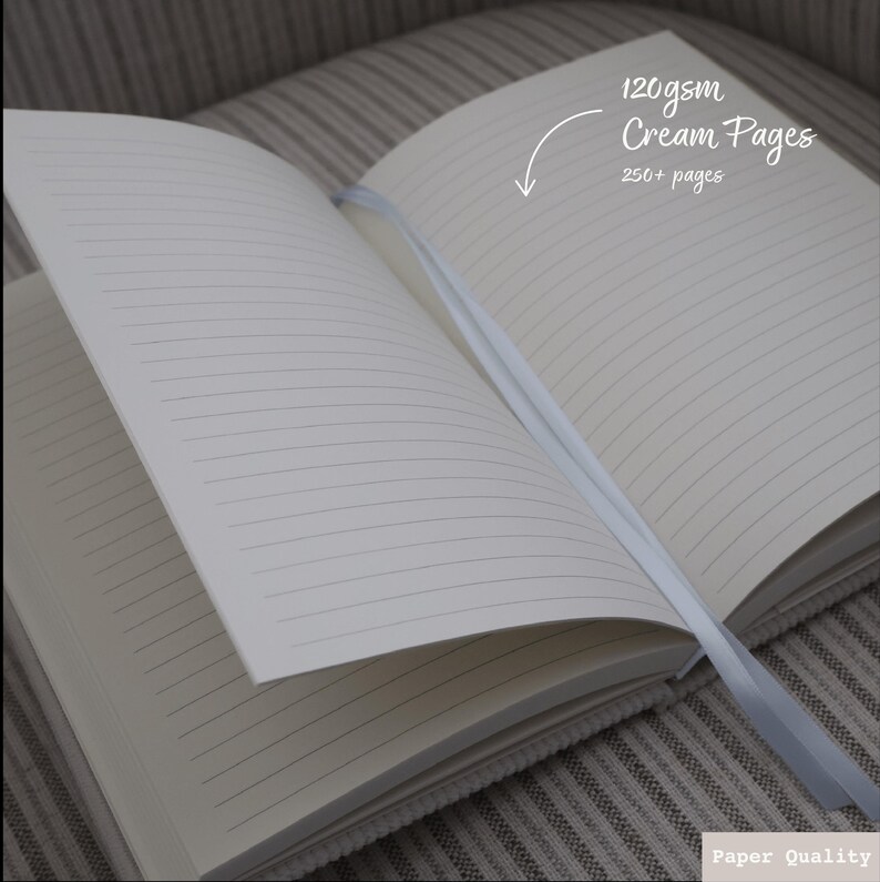 Puede incluir: Cuaderno abierto con p&aacute;ginas de color crema y papel rayado. El cuaderno tiene un marcador de cinta y el texto "120gsm Cream Pages 250+ pages" es visible en la p&aacute;gina derecha.