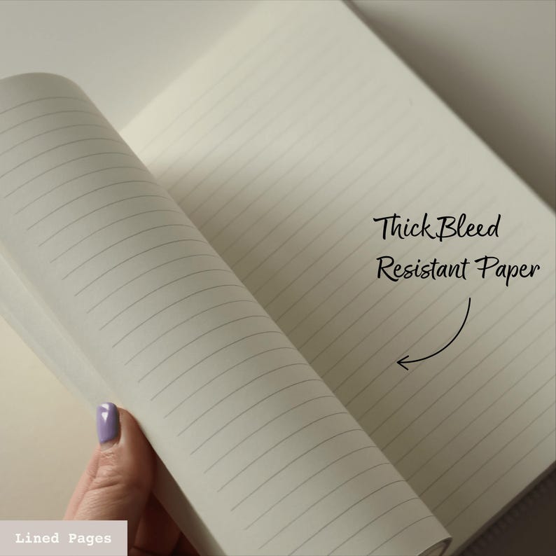Puede incluir: Primer plano de un cuaderno con p&aacute;ginas rayadas. Las p&aacute;ginas son gruesas y resistentes a la tinta. El texto "Thick Bleed Resistant Paper" est&aacute; escrito en el lado derecho de la imagen.