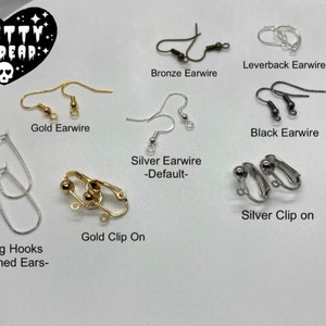 May include: Assortment of earring findings in gold, silver, and black.  Includes leverback earwires, earwires, clip-on earrings, and earring hooks for stretched ears.