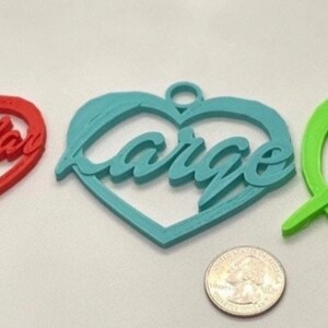 May include: Four heart-shaped ornaments in different sizes and colors. The smallest is pink and says "Small", the next is red and says "Regular", the largest is blue and says "Large", and the last is green and says "XL".