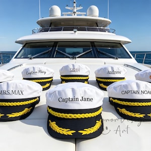 May include: A collection of white captain hats with black brims, yellow braided trim, and gold embroidered laurel leaves. Each hat features custom text including Sadie, Captain Mary, Sarah, Andrew, SHIRLEY, MRS.MAX, Captain Jane, and CAPTAIN NOAH.