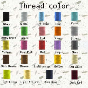 May include: A color chart displaying twenty-five spools of sewing thread arranged in a grid. Each spool is labeled with its corresponding color name, including black, white, light blue, blue, cyan, army green, green, pink, orange, silver, yellow, rose pink, red, purple, grey, dark brown, brown, light orange, golden, off white, light green, light yellow, dark blue, and dark red.