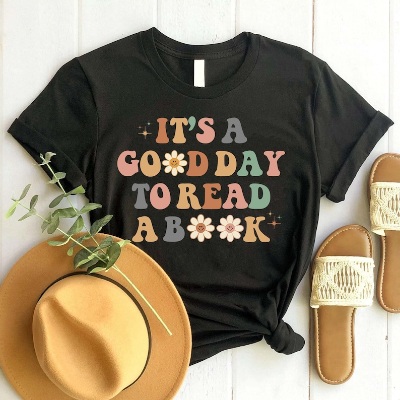 May include: Black t-shirt with the text "It's a good day to read a book" in colourful letters with flower accents.
