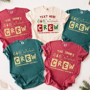 May include: Five short-sleeved crew neck t-shirts in red, cream, and dark green. Each shirt features a graphic with the text "Christmas CREW" and "MAKING MEMORIES TOGETHER," with some shirts personalized with "THE JOHN'S" or "TEXT HERE."