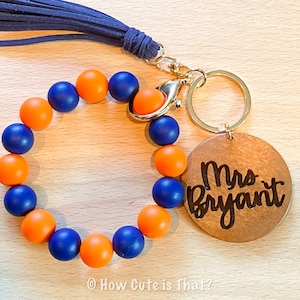 Peut inclure: Un porte-cl&eacute;s en perles bleues et orange avec une &eacute;tiquette en bois qui dit "Mme Bryant".