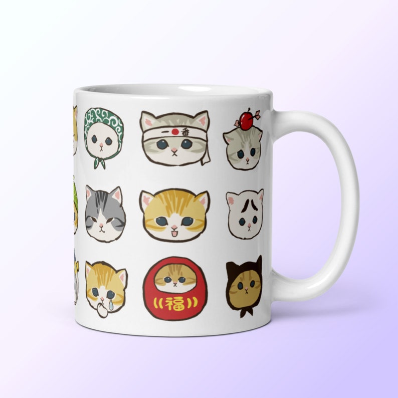 Puede incluir: Taza de cer&aacute;mica blanca con un patr&oacute;n de lindos gatos de dibujos animados con diferentes expresiones y accesorios. Los gatos llevan sombreros, bandanas y otros art&iacute;culos. La taza tiene un amuleto de la suerte japon&eacute;s rojo y blanco con la palabra "福" (que significa "buena fortuna") en &eacute;l.