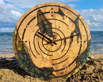May include: A round wooden clock with black hands and a green and gold resin inlay. The clock face has a circular pattern of concentric circles and dots.