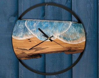 May include: A round wooden clock with a black metal frame. The clock face features a blue and white resin wave design.