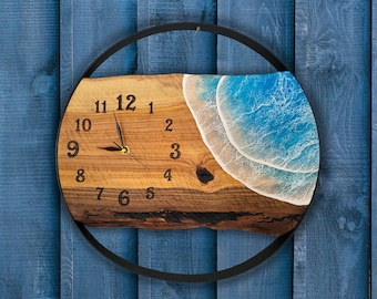 Può includere: Un orologio in legno con cornice in metallo nero, che presenta un design a onda in resina blu e bianca. Il quadrante dell'orologio ha numeri e lancette neri.