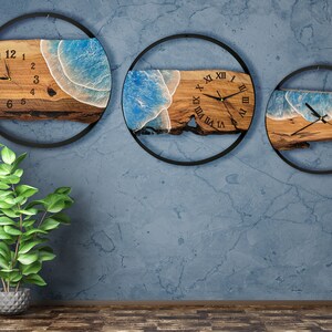 Olive wood and metal  wall clock
Close-up of resin ocean art on clock
Timeless Tides clock on a rustic wall
Customizable modern olive wood clock
Unique wall clock perfect for gifts