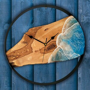 Olive wood and metal  wall clock
Close-up of resin ocean art on clock
Timeless Tides clock on a rustic wall
Customizable modern olive wood clock
Unique wall clock perfect for gifts