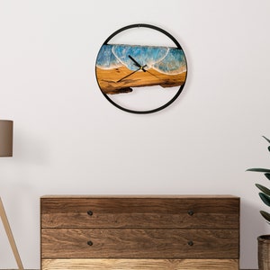 Olive wood and metal  wall clock
Close-up of resin ocean art on clock
Timeless Tides clock on a rustic wall
Customizable modern olive wood clock
Unique wall clock perfect for gifts