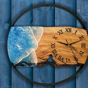 Olive wood and metal  wall clock
Close-up of resin ocean art on clock
Timeless Tides clock on a rustic wall
Customizable modern olive wood clock
Unique wall clock perfect for gifts