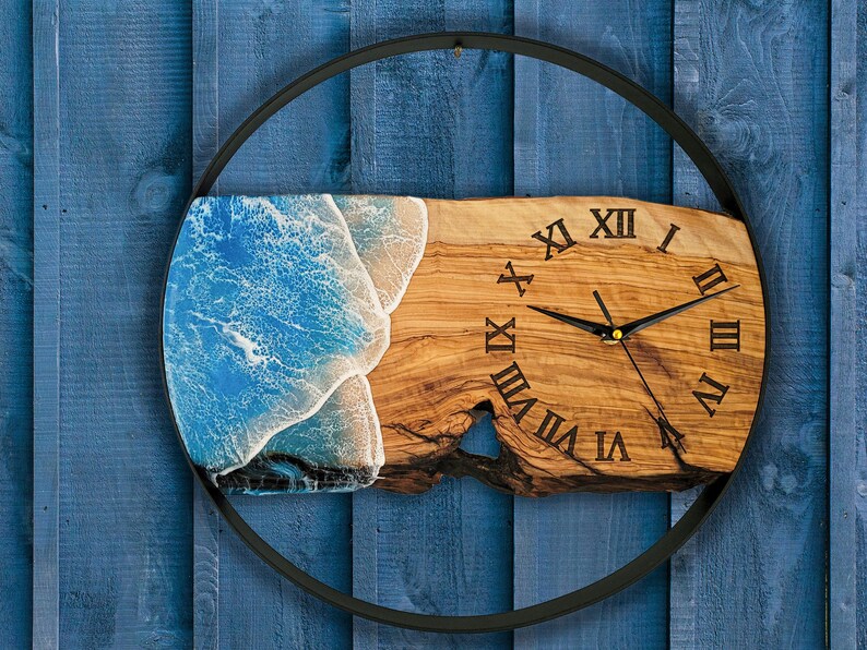 Olive wood and metal  wall clock
Close-up of resin ocean art on clock
Timeless Tides clock on a rustic wall
Customizable modern olive wood clock
Unique wall clock perfect for gifts