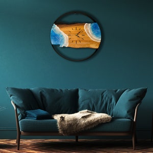 Olive wood and metal  wall clock
Close-up of resin ocean art on clock
Timeless Tides clock on a rustic wall
Customizable modern olive wood clock
Unique wall clock perfect for gifts