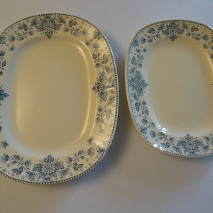 Op de afbeelding: Twee ovale serveerschalen met een blauw en wit bloemenpatroon. De grotere schaal is ovaalvormig en de kleinere schaal is rechthoekig.
