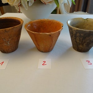 Könnte beinhalten: Drei Terrakotta-Töpfe, einer mit brauner Glasur, einer mit orangefarbener Glasur und einer mit grüner Glasur. Die Töpfe sind mit 1, 2 und 3 nummeriert.