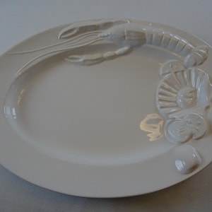 May include: White ceramic oval serving platter with a raised design of a lobster and various seashells.