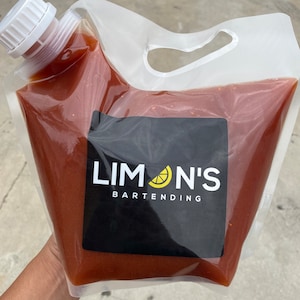 May include: A clear plastic bag filled with a red liquid. The bag has a spout and a handle. The bag has a black label with the text "LIMON'S BARTENDING" and a yellow lemon icon.