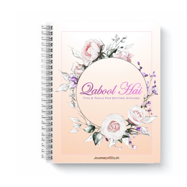 May include: A spiral bound notebook with a peach background and a floral wreath design. The wreath is made of white and pink roses, purple flowers, and green leaves. The text "Qabool Hai" is written in pink script inside the wreath. The text "Tips & Tools for Getting Hitched" is written in black below the wreath. The text "Journeyof2byak" is written in black at the bottom of the page.