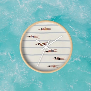 Könnte beinhalten: Ein rundes, weißes Zifferblatt mit schwarzen Zeigern und einem Holzrahmen. Das Zifferblatt hat ein gestreiftes Muster und zeigt Silhouetten von Menschen beim Schwimmen.