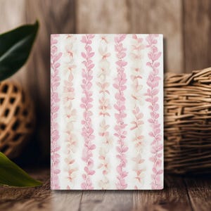 A white notebook with a pink flower lei floral pattern