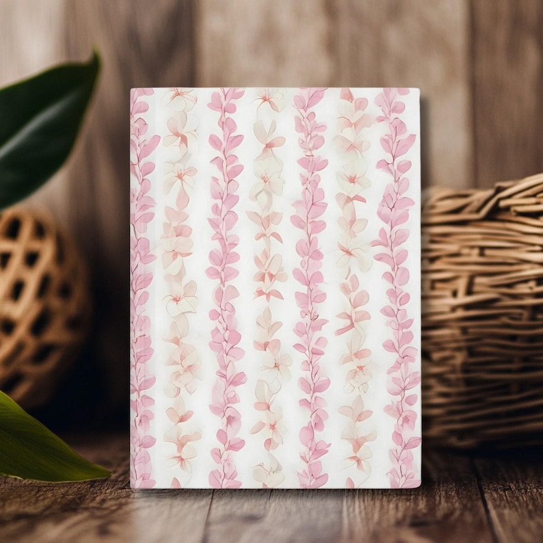 A white notebook with a pink flower lei floral pattern
