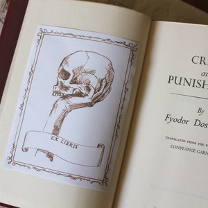 Puede incluir: Un libro vintage titulado "Crimen y Castigo" de Fi&oacute;dor Dostoievski, con una ilustraci&oacute;n dibujada a mano de una calavera en la portada.