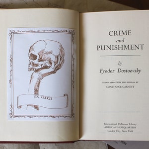Puede incluir: Un libro vintage titulado "Crimen y Castigo" de Fi&oacute;dor Dostoievski. La portada del libro presenta una mano sosteniendo una calavera con las palabras "Ex Libris" en una pancarta.