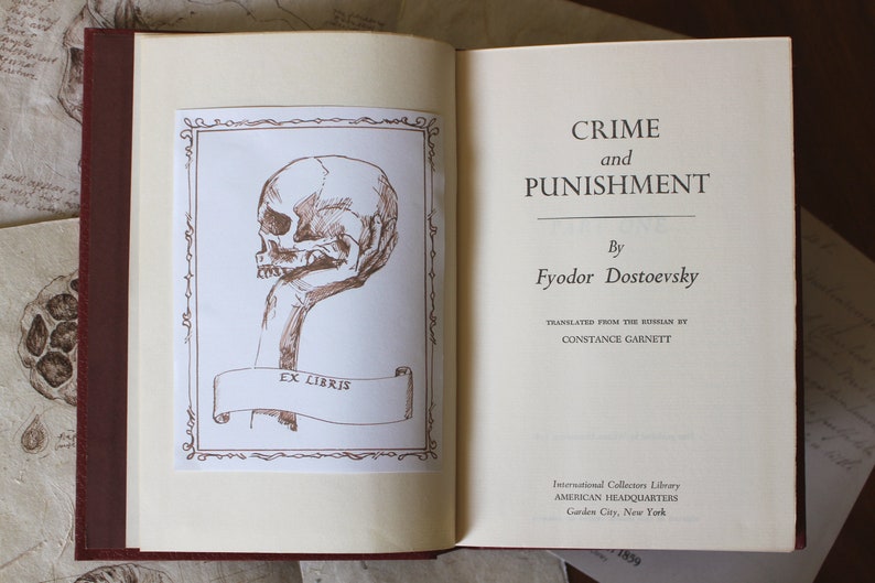 Puede incluir: Un libro vintage titulado "Crimen y Castigo" de Fi&oacute;dor Dostoievski. La portada del libro presenta una mano sosteniendo una calavera con las palabras "Ex Libris" en una pancarta.